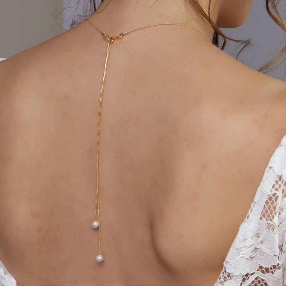 Bijou de dos perles blanches et chaine dorée Bijou de dos perles blanches et chaine dorée